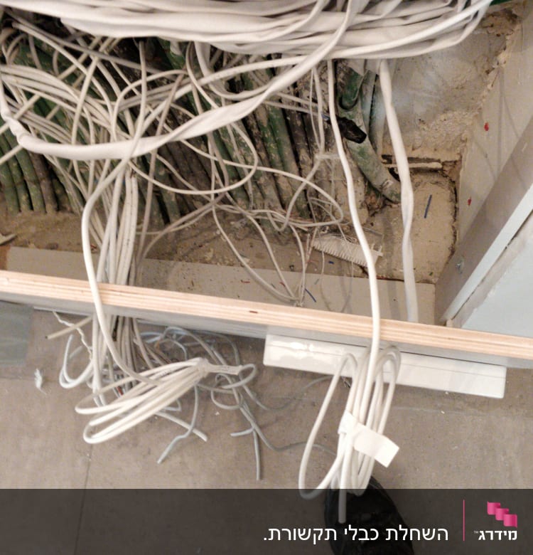 חוטי חשמל לבנים וירוקים מסודרים בקיר